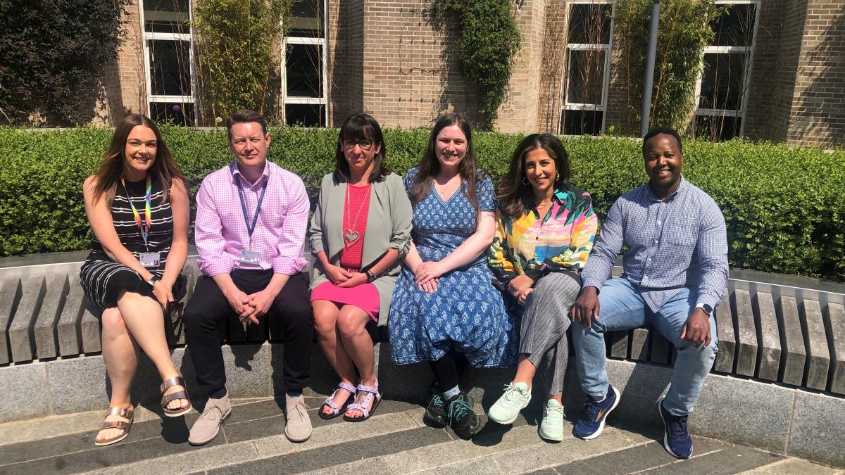 Six Student Advisers sitting in the sun outside the James Clerk Maxwell Building at King's Buildings.