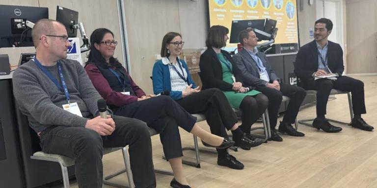 Five people sitting for a panel discussion
