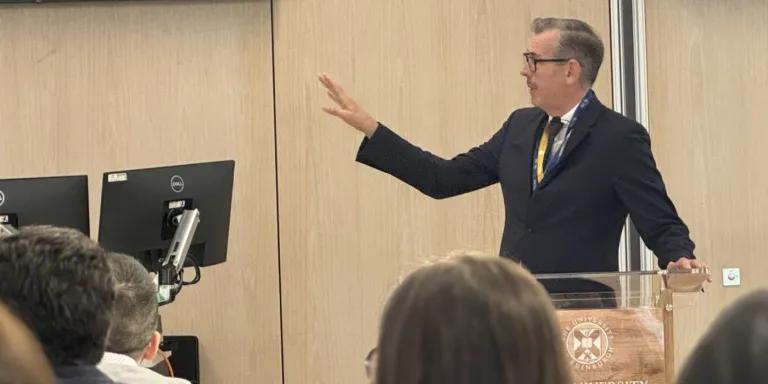 A man presenting at the front of a room