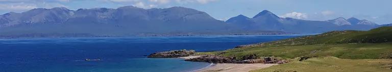 Landscape image of a bay on the Isle of rum, and the view out across the water to other mountainous islands