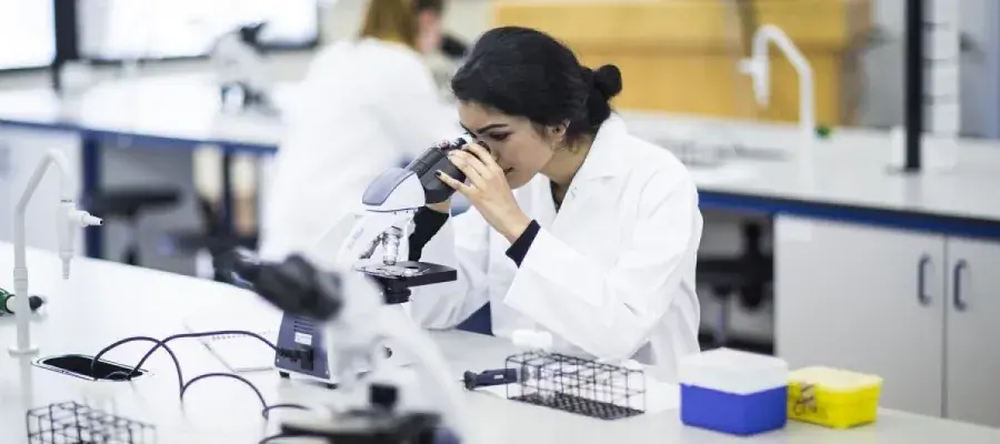 A Biomedical Science Student Looking into a Microscope in a Lab