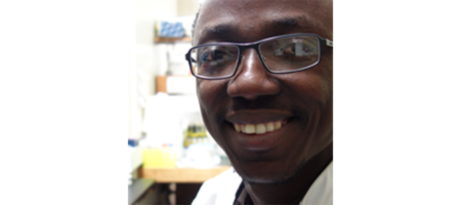 Headshot of smiling Dr. Kwabena Duedu in a lab.
