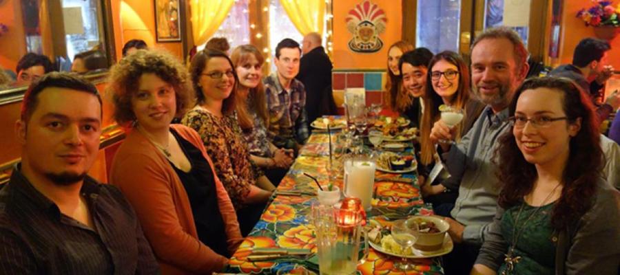 Group photo of lab members seated around a resataurant table