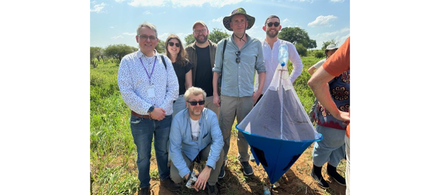 Matthews research group standing in a park holding a tsetse fly trap.
