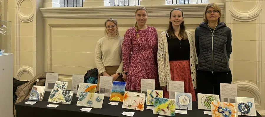 Four participating artists at the exhibition stand with the tile artworks.