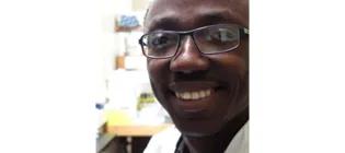 Headshot of smiling Dr. Kwabena Duedu in a lab.