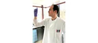 Marcos holding a test tube in a lab.