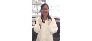 Dr. Olivia Wei Liu standing in a lab and smiling.