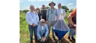Matthews research group standing in a park holding a tsetse fly trap.