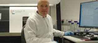 Christopher Hall sitting in front of a BD FACSDiscover S8 flow cytometer