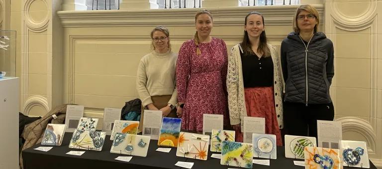 Four participating artists at the exhibition stand with the tile artworks.