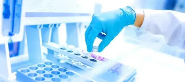 Image of scientists gloved hand at lab bench