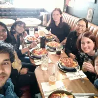Seven group members gathered around a table to share a meal.