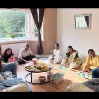 Group members gathered ina home to eat around a small table.