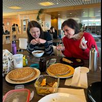 Two group members share a joke whilst enjoying pancakes.