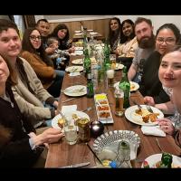 Group members gathered round a table to share a meal