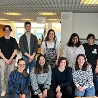 Group photo of the lab members gathered in two rows and smiling for the camera