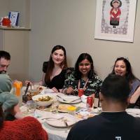 Group members gathered around a table to share a meal.