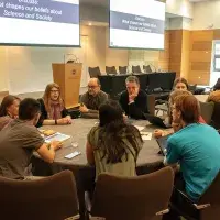 Image of delegates discussing around a table