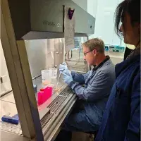 Two people in lab coats working together in a laboratory.