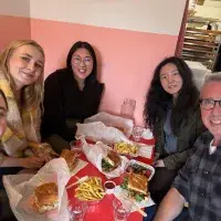 A group of people sitting around a table with food