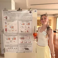 A person standing next to a research poster titled “Induction of pulmonary type 2 responses by the helminth Schistosoma mansoni,” featuring graphs, diagrams, and tables summarising immune response data.