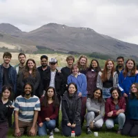 Members of the Hardwick and JP labs assemble for a group photo smiling in front of Firbush outdoor centre