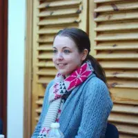 A lab member sitting indoors wearing a colourful winter scarf