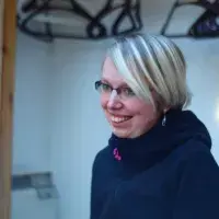A lab member wearing ski jacket indoors, smiling