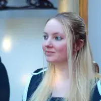 A lab member indoors looks away from camera