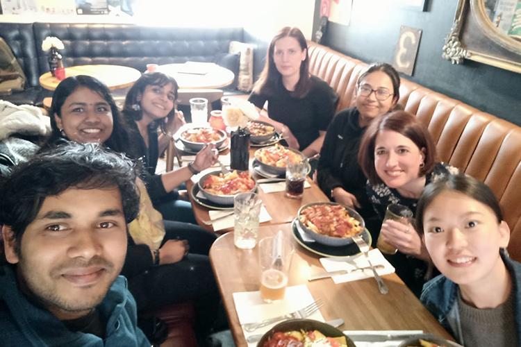 Seven group members gathered around a table to share a meal.