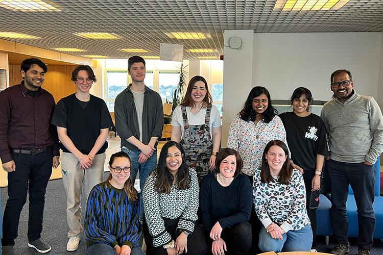 Group photo of the lab members gathered in two rows and smiling for the camera