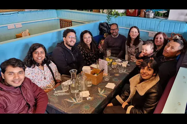 Group members gathered round a table to share a meal