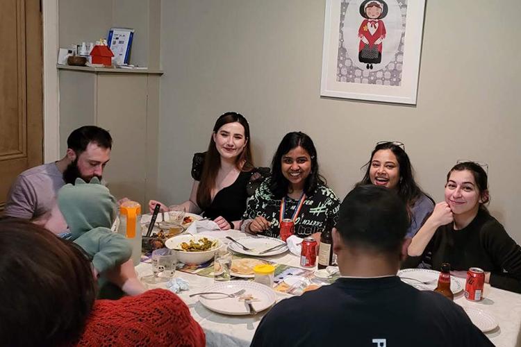 Group members gathered around a table to share a meal.