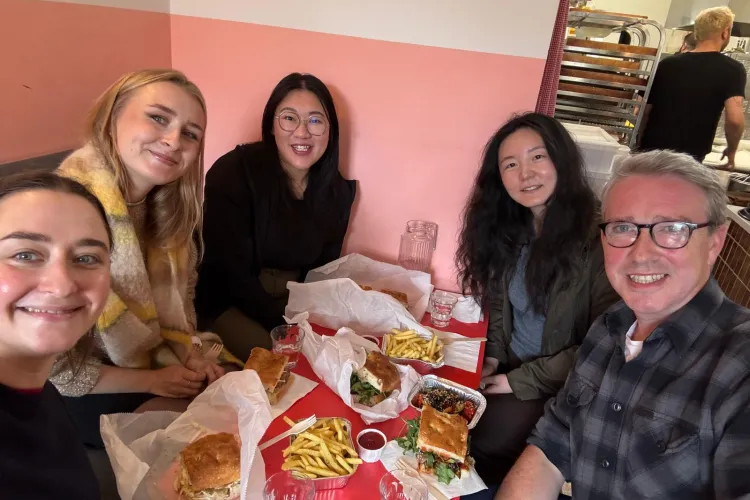 A group of people sitting around a table with food