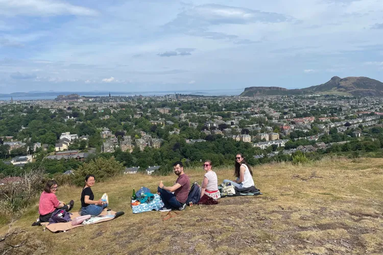 Five people having a picnic on Blackford Hill on a sunny day
