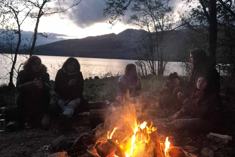 A bonfire is surrounded by some lab members next to Loch Tay
