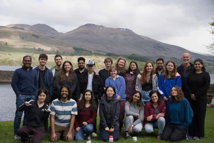 Members of the Hardwick and JP labs assemble for a group photo smiling in front of Firbush outdoor centre