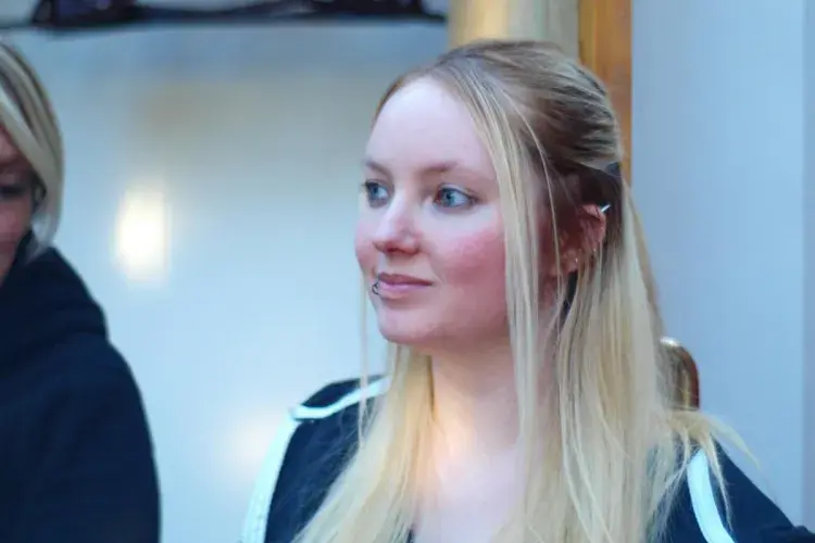 A lab member indoors looks away from camera
