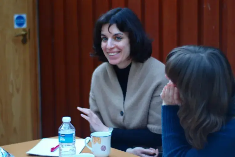 Two lab members sit side by side and share a laugh