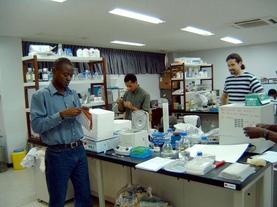 Three men standing in a lab and viewing the equipment.