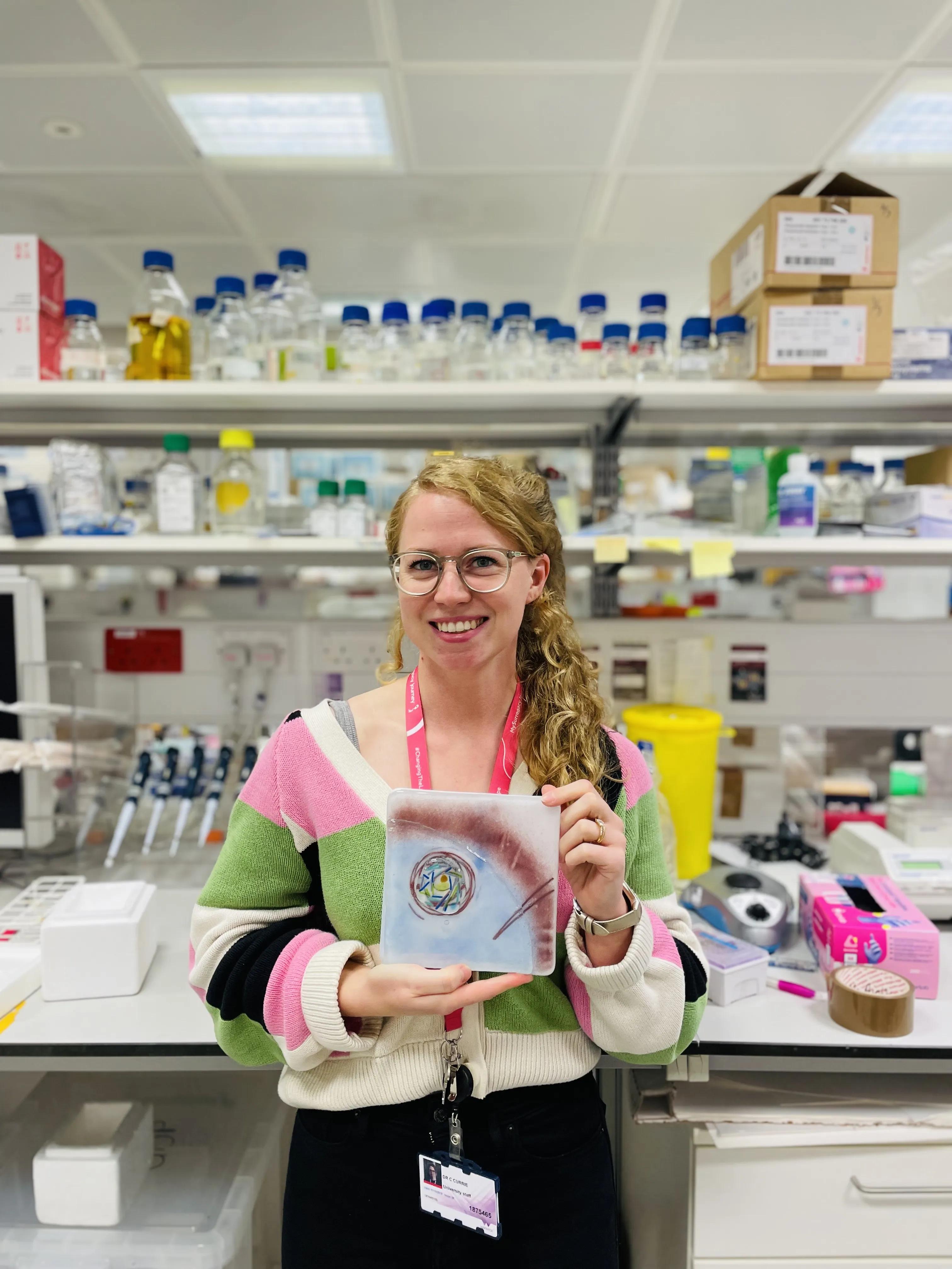 Cerys Currie with her tile artwork "The tale of oocyte development".