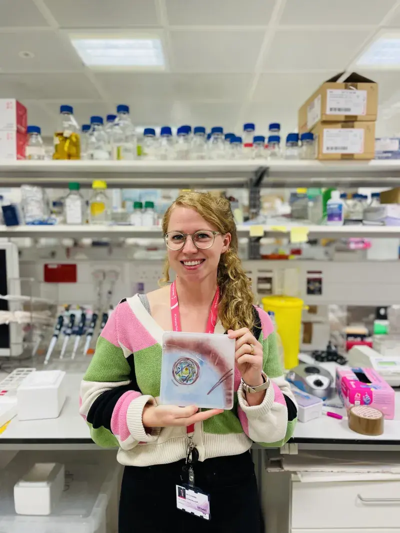 Cerys Currie with her tile artwork "The tale of oocyte development".