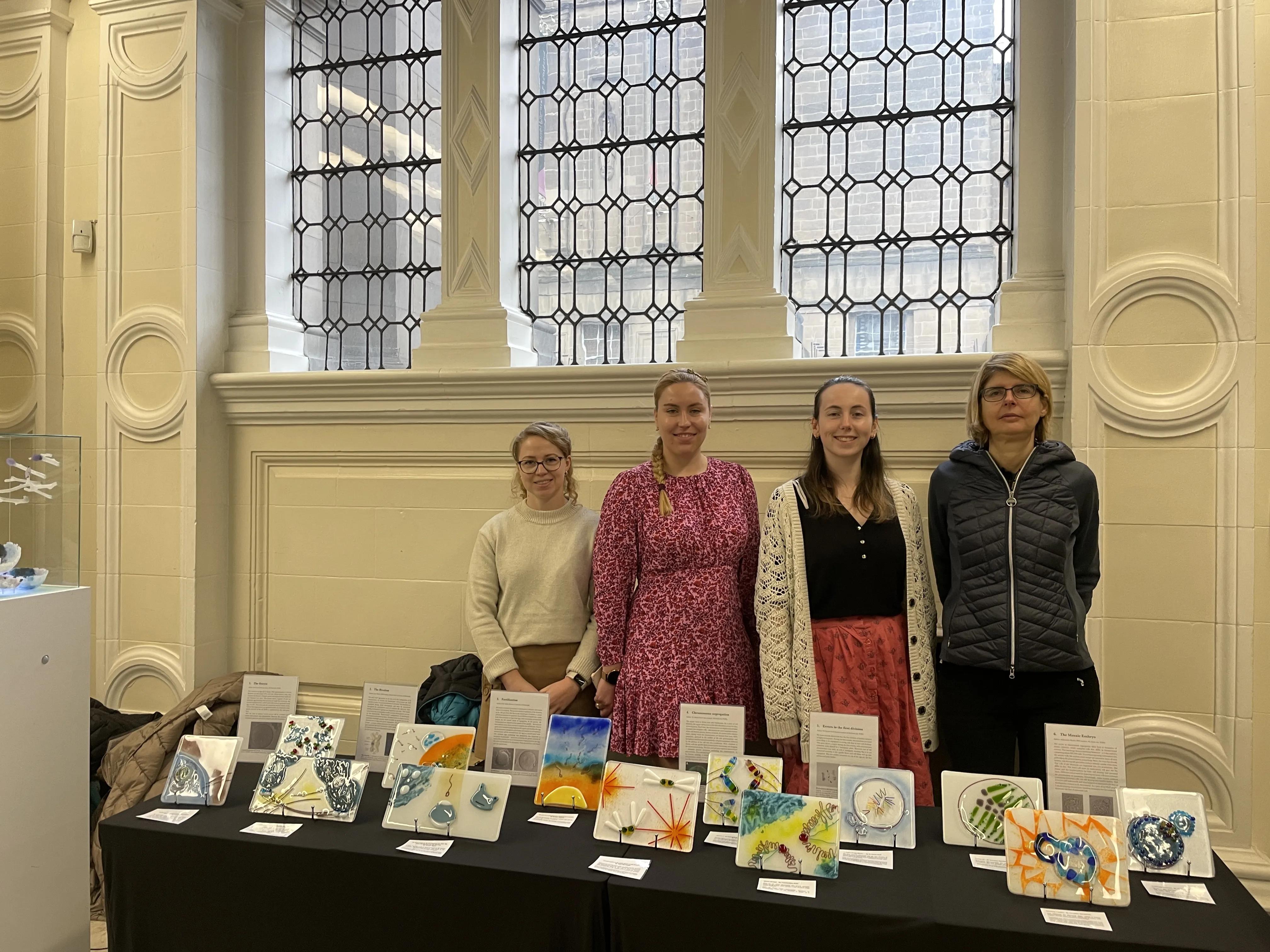 Four contributing artists standing at the exhibition stand with the tile artworks.