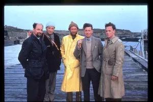 Five men standing on a pier and posing for a photograph.