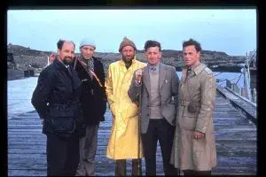 Five men standing on a pier and posing for a photograph.
