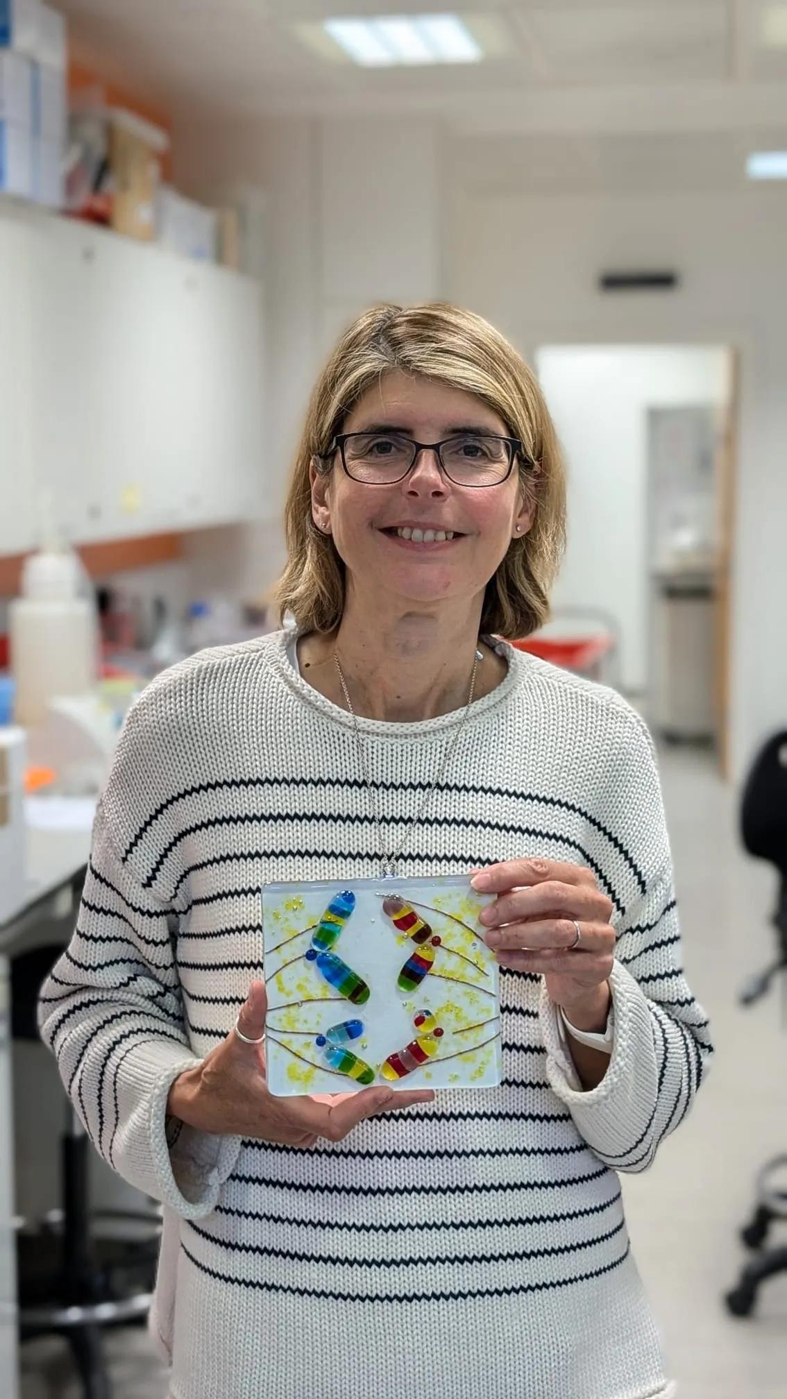 Muriel Erent with her tile artwork "Genetic Mosaic: gene transfer through generations".