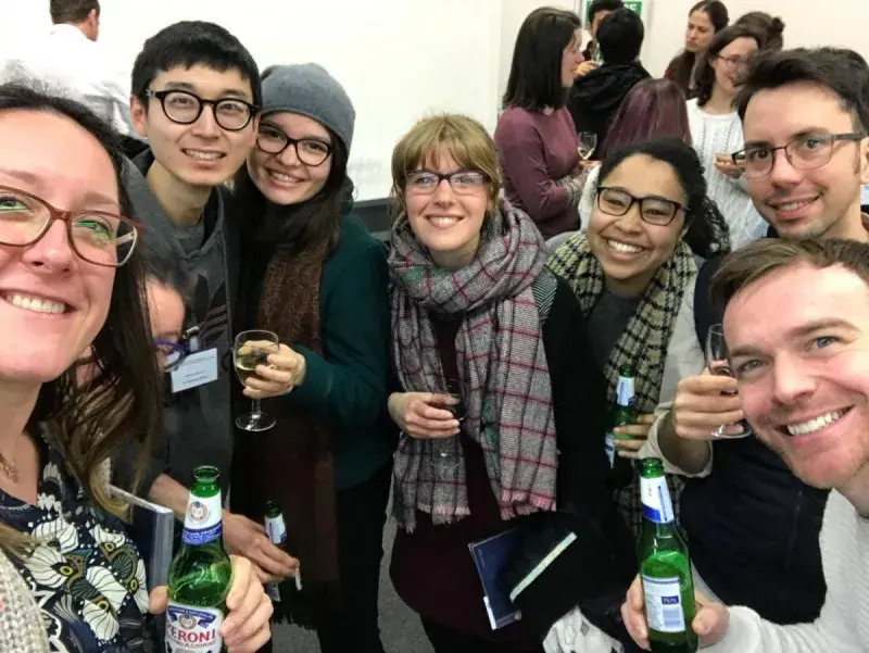 Photo of the lab group members smiling for a group photo with drinks in hands