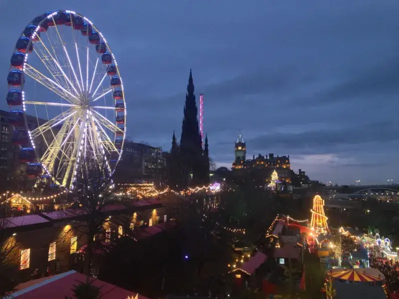 Photo of the big wheel at Edinburgh's Christmas market with the Edinburgh skyline behind