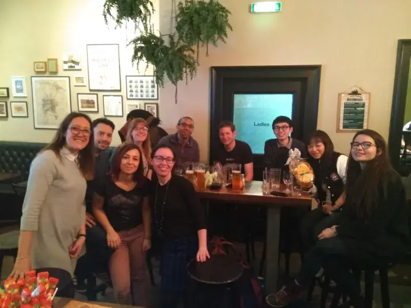 Photo of the lab group members in a pub gathered round a table with drinks